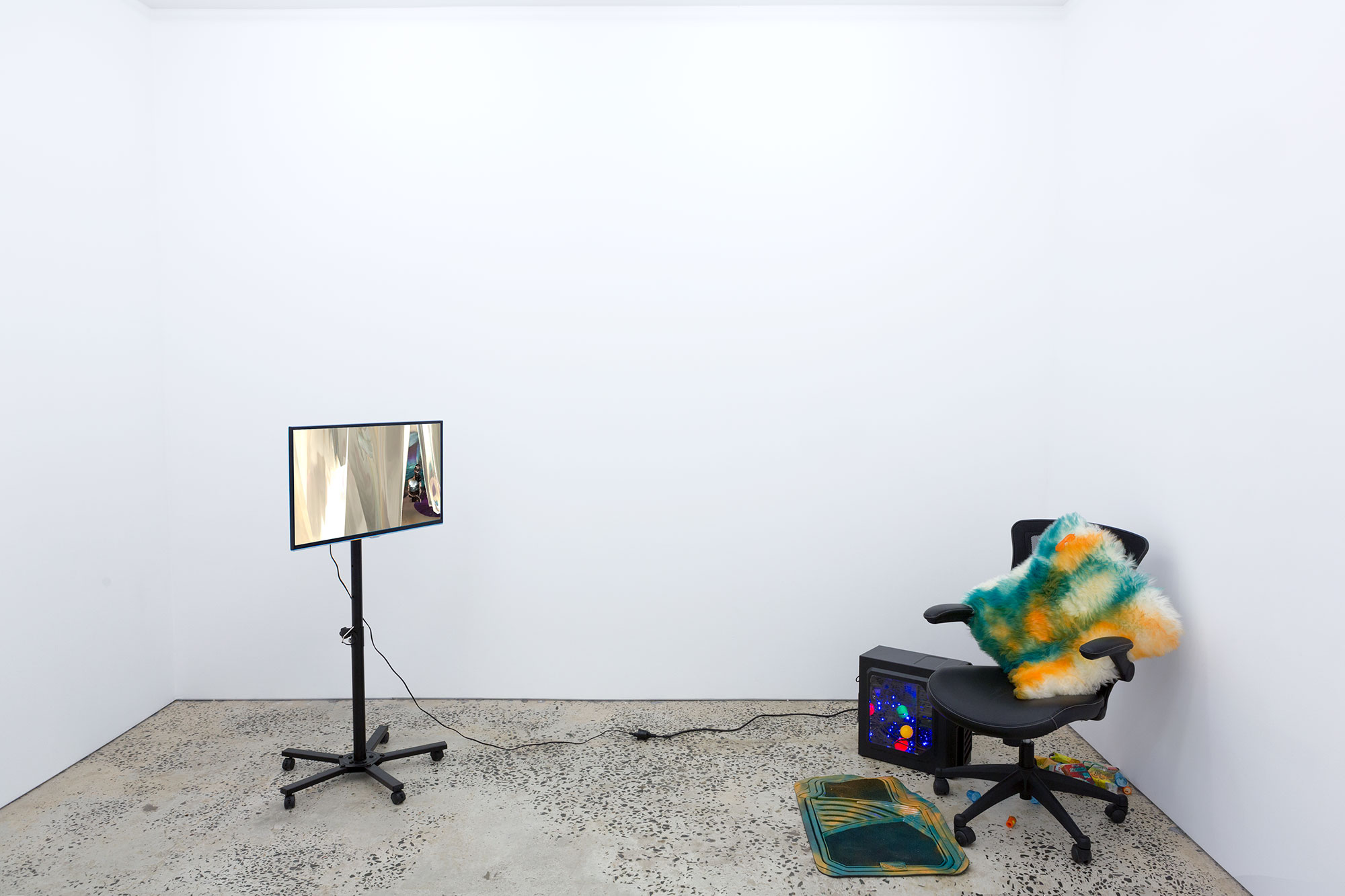 “Contemporary Monsters”, 2016, two-channel digital video, jelly shot glasses, gel wax, car air freshener, sheepskin, enamel paint, cereal, rubber mat, LED lights, computer tower, 11 minutes, 19 seconds